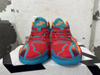 Front view of red Jordan basketball shoes with blue mesh tongues, orange accents and blue soles.