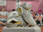 Pair of light gray Jordan high-top sneakers with champagne-gold details