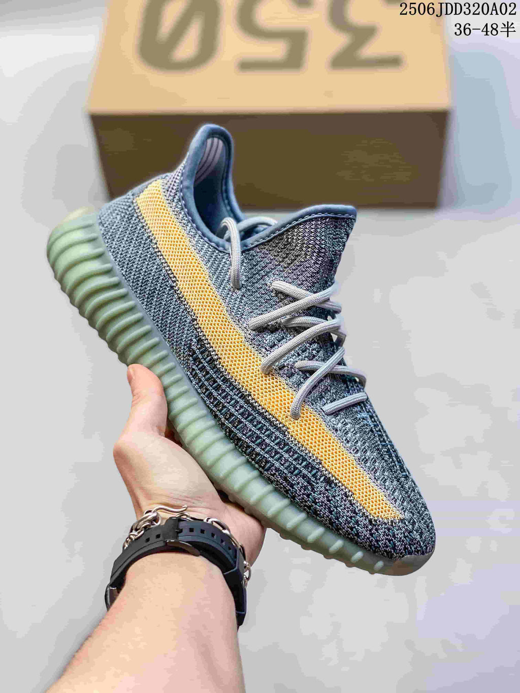 Gray knit sneaker with a yellow side stripe, light laces, and a pale green-gray ribbed sole.