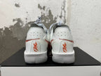 Rear view of white Nike sneakers with red accents and heel branding