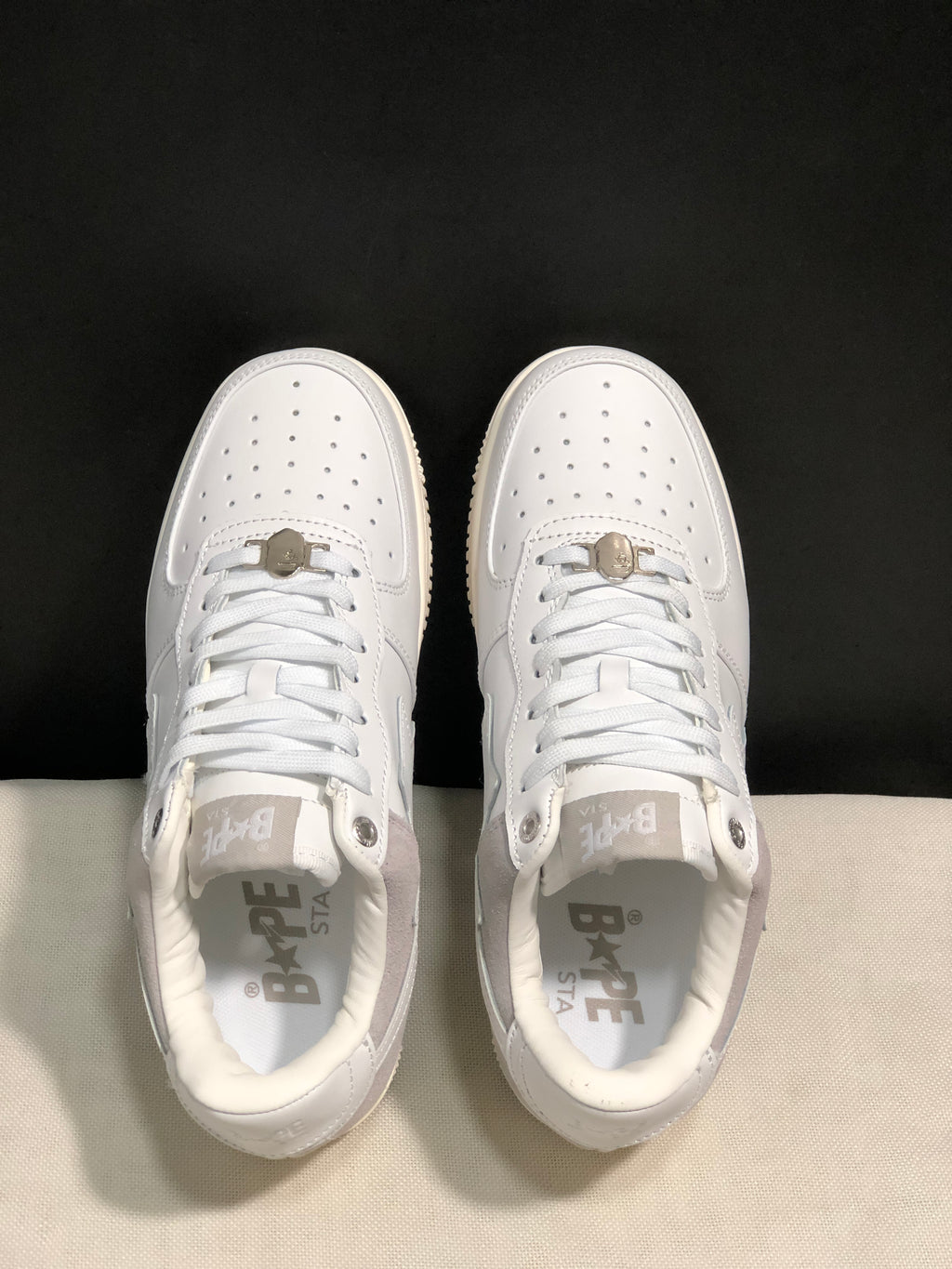 Top-down view showing the perforated toe boxes, white laces, padded collars, and branded insoles.
