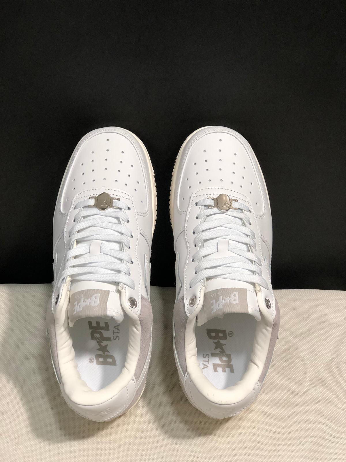 Top-down view showing the perforated toe boxes, white laces, padded collars, and branded insoles.