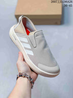 Three-quarter view showing the light gray upper, three side stripes, Climacool marking, white midsole, and black outsole.