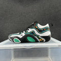 Side view of black, white, and green Jordan low-top sneakers with floral-patterned panels