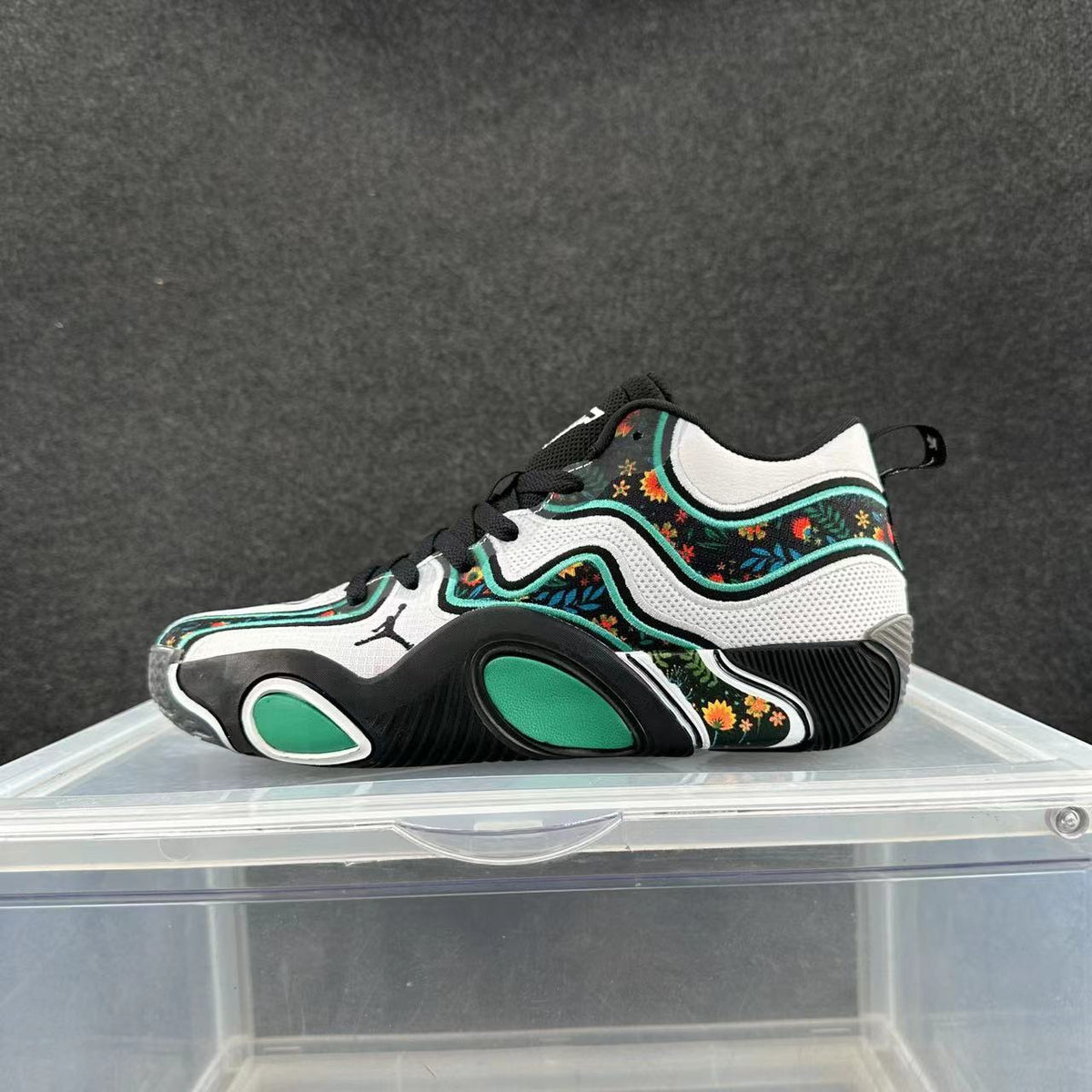 Side view of black, white, and green Jordan low-top sneakers with floral-patterned panels