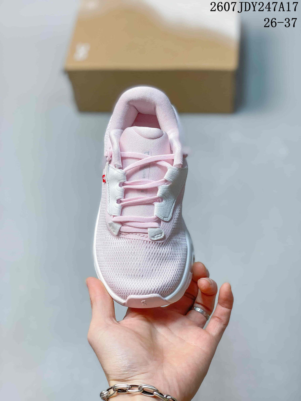 Top view showing the pale pink laces, padded tongue, collar, and textured toe box.