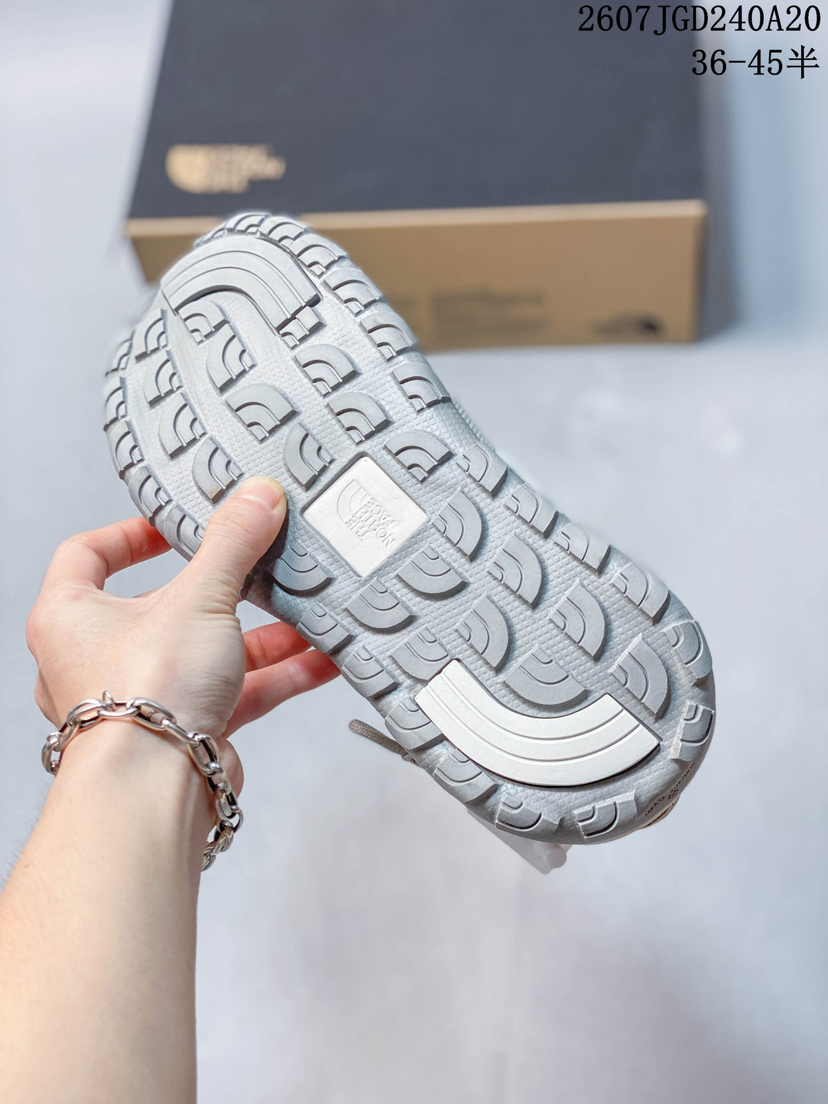 Close-up of the sandal outsole showing a segmented textured tread pattern and central molded detail.