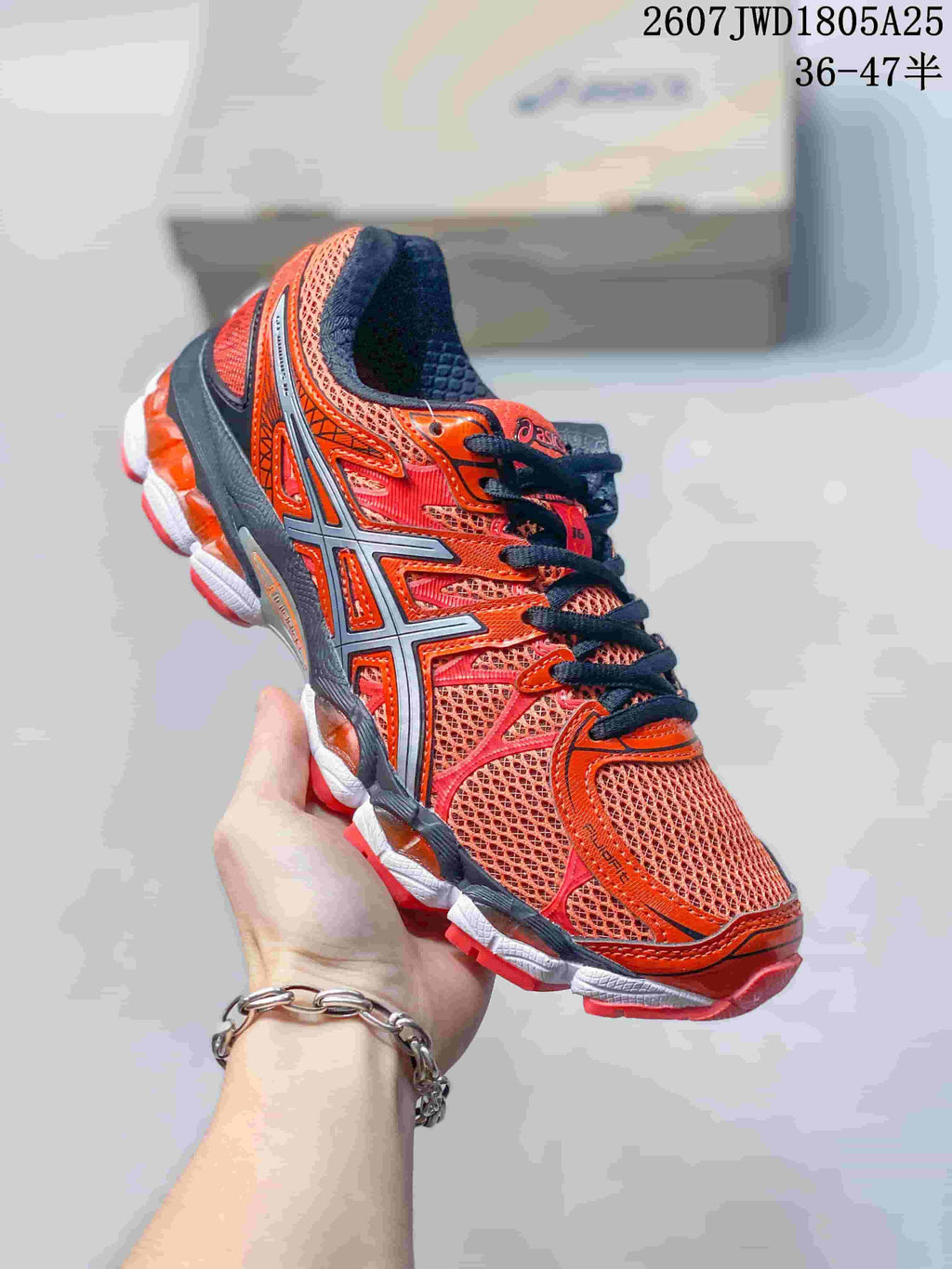 Angled side view of the red and orange ASICS Gel-Nimbus 16 shoe with black laces and contrasting sole.