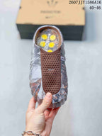 Top view of a single sandal showing the brown perforated strap, small logo detail, and marbled footbed area.
