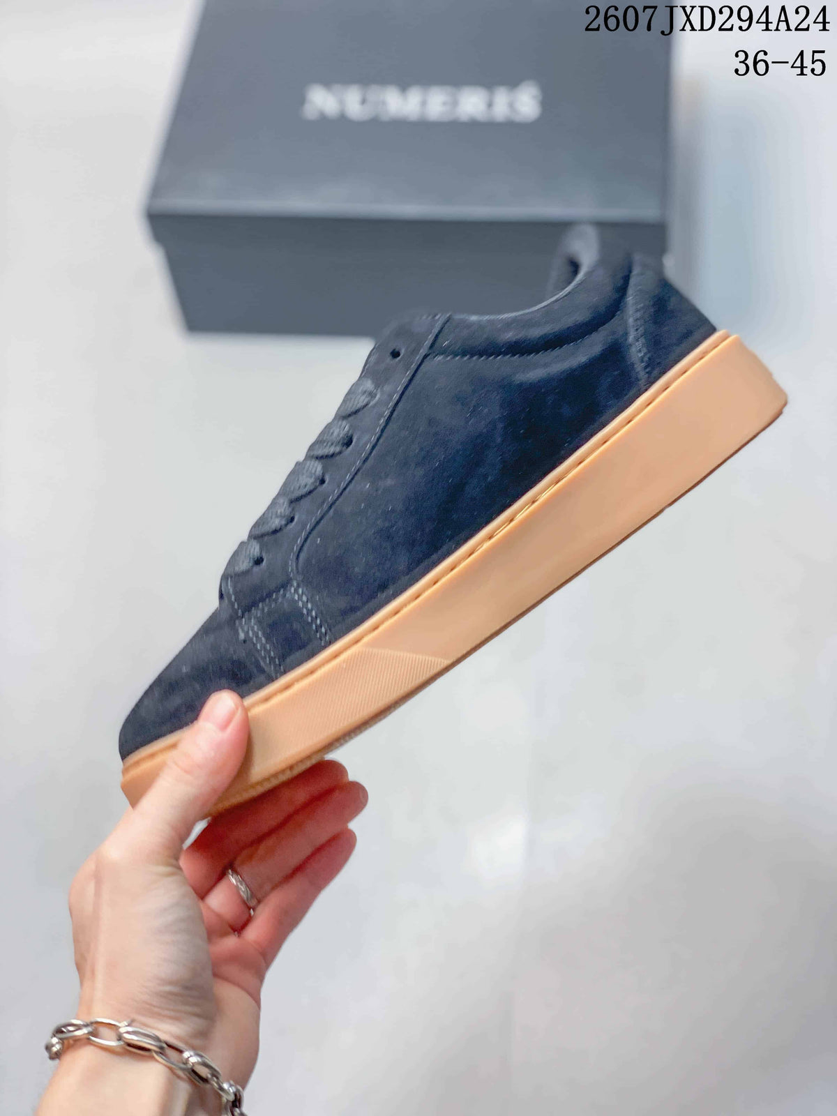 Side view of the dark navy sneaker highlighting the stitched upper panels and raised gum-colored sole.
