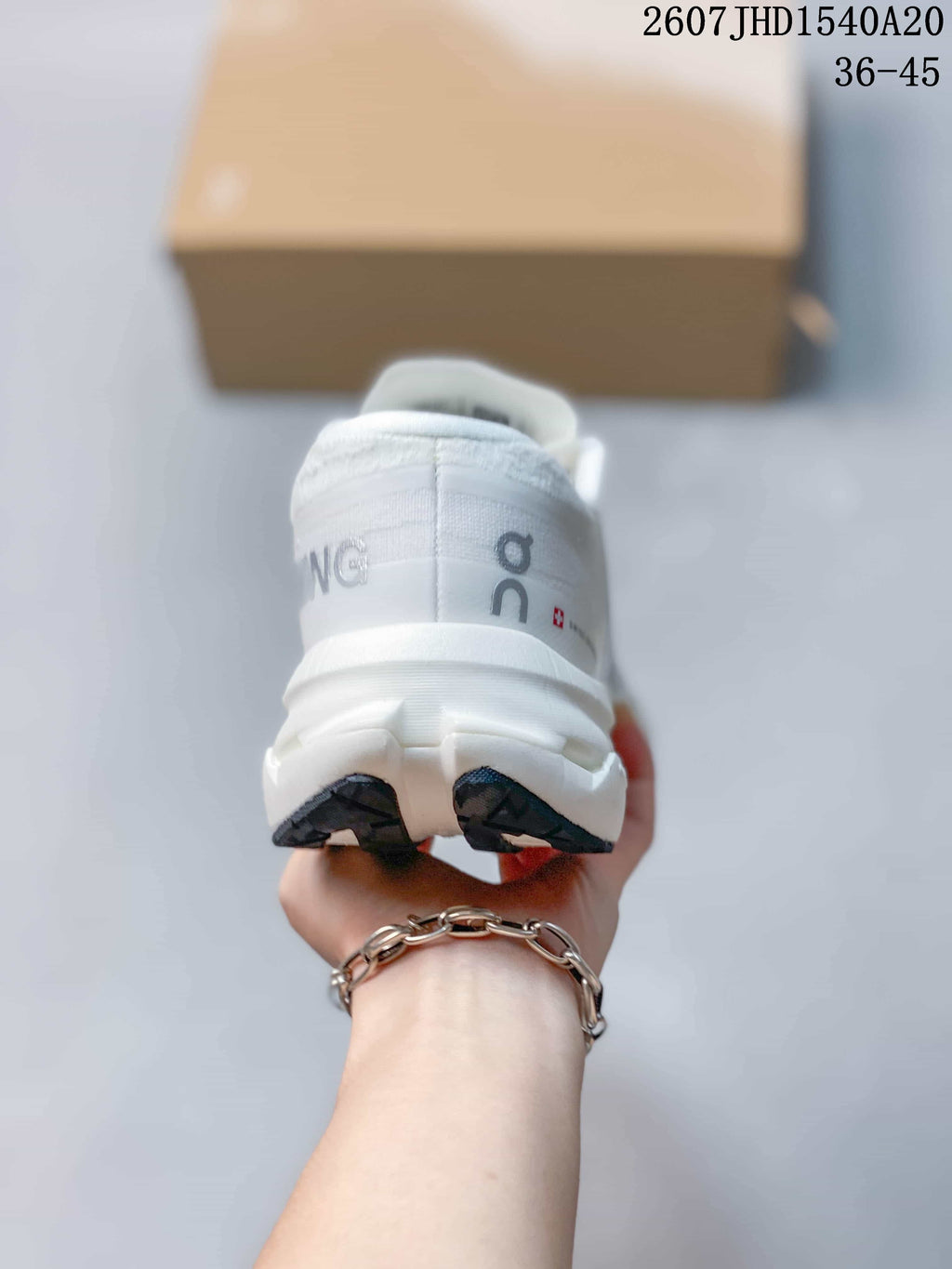 Rear view of the white sneaker showing the padded heel collar, gray branding, and dark outsole edges.