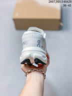 Rear view of the white sneaker showing the padded heel collar, gray branding, and dark outsole edges.