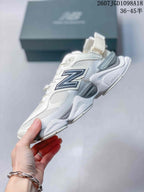 Side profile of a white and light grey New Balance 9060 sneaker highlighting the large contrast N logo, mesh panels and sculpted midsole.