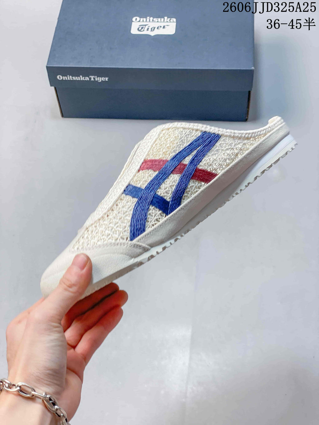 Side view of the sneaker showing the open-pattern upper, blue and red stripes, and low-profile sole.