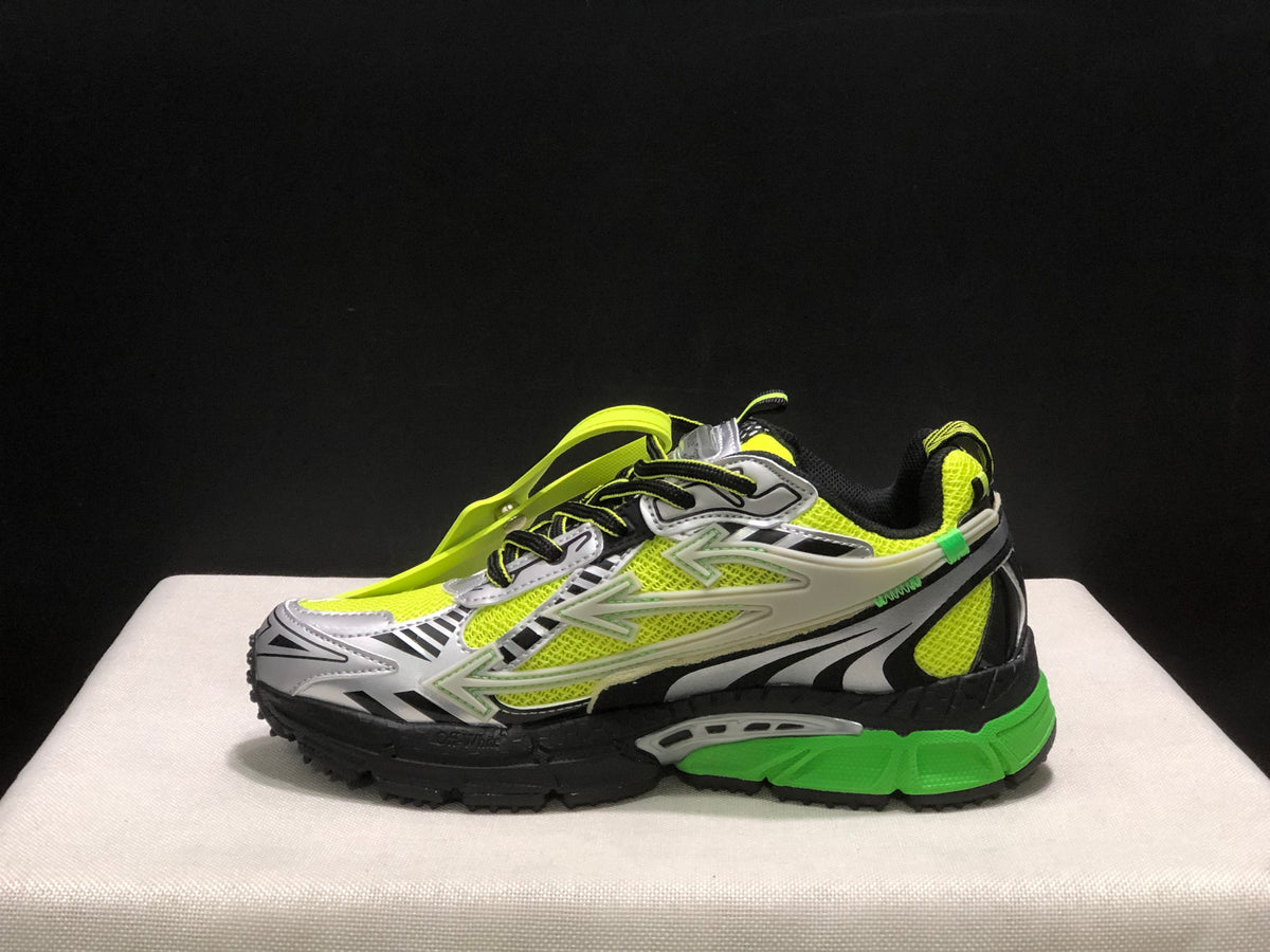 Side view of one sneaker showing the neon upper, black laces, silver overlays, and sculpted green-and-black sole.