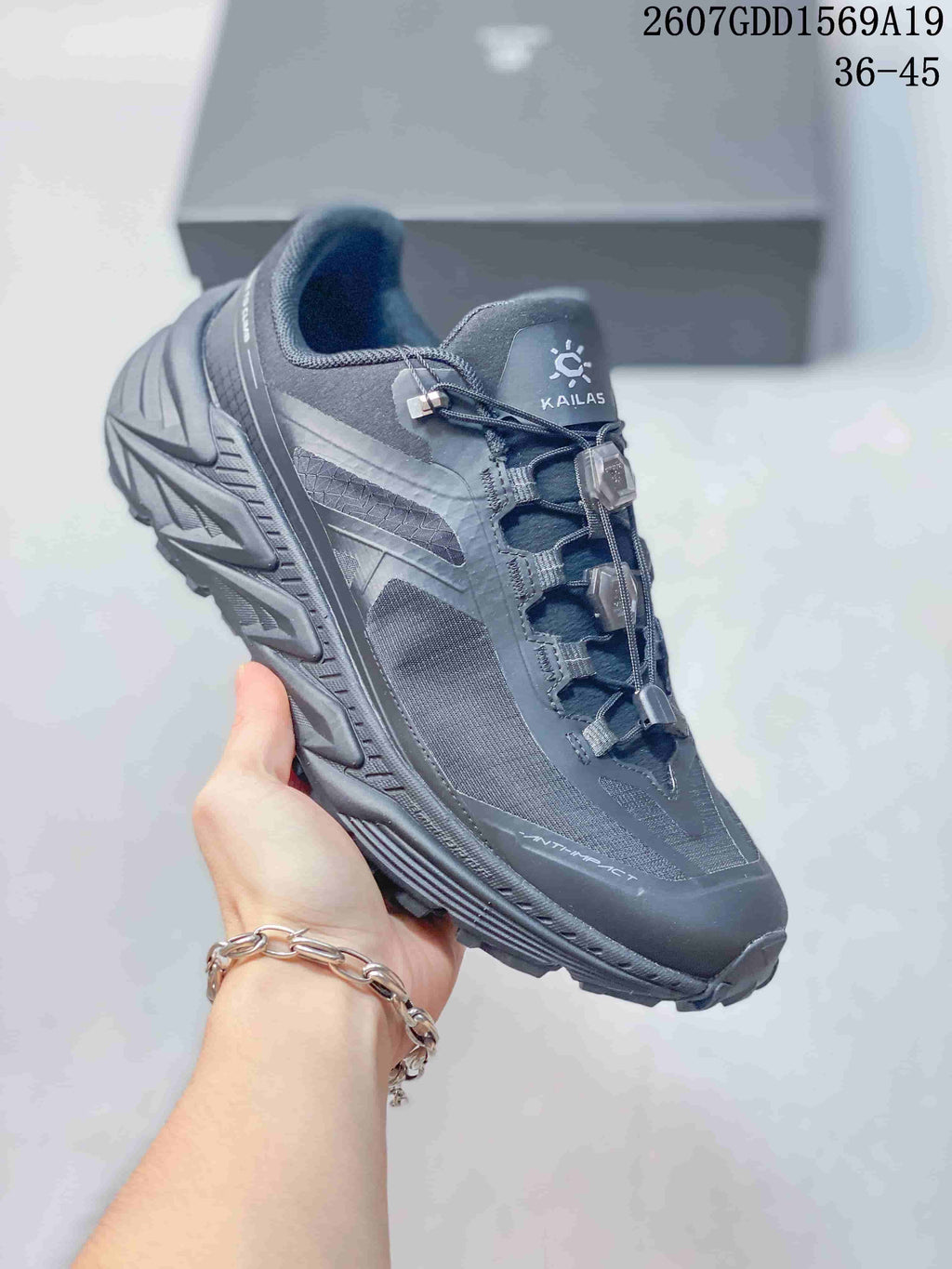 Close side view of a dark gray KAILAS trail shoe showing the structured upper, quick-lacing hardware and textured outsole.