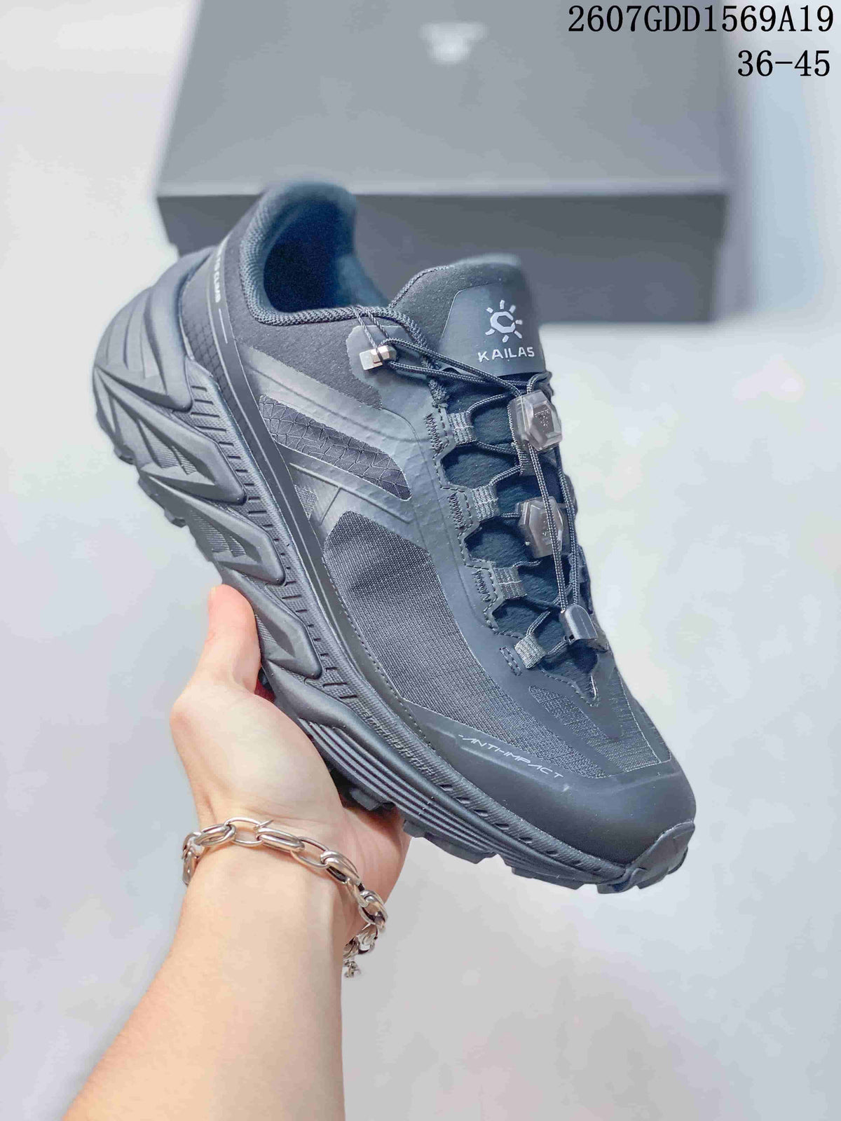 Close side view of a dark gray KAILAS trail shoe showing the structured upper, quick-lacing hardware and textured outsole.