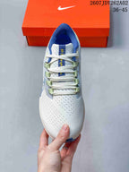 Top view of a Nike Pegasus 38 shoe with white laces and blue and green accents.