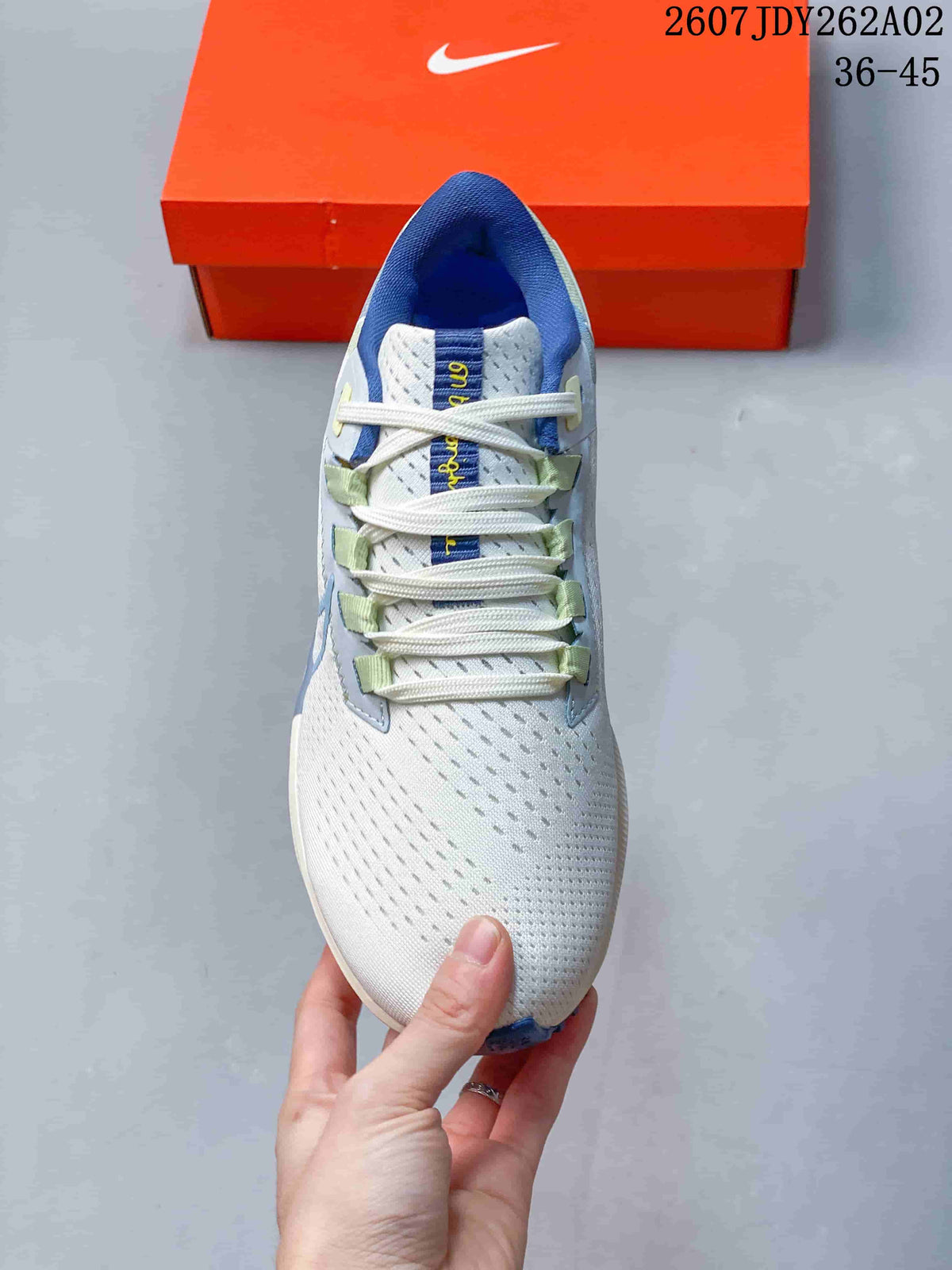 Top view of a Nike Pegasus 38 shoe with white laces and blue and green accents.