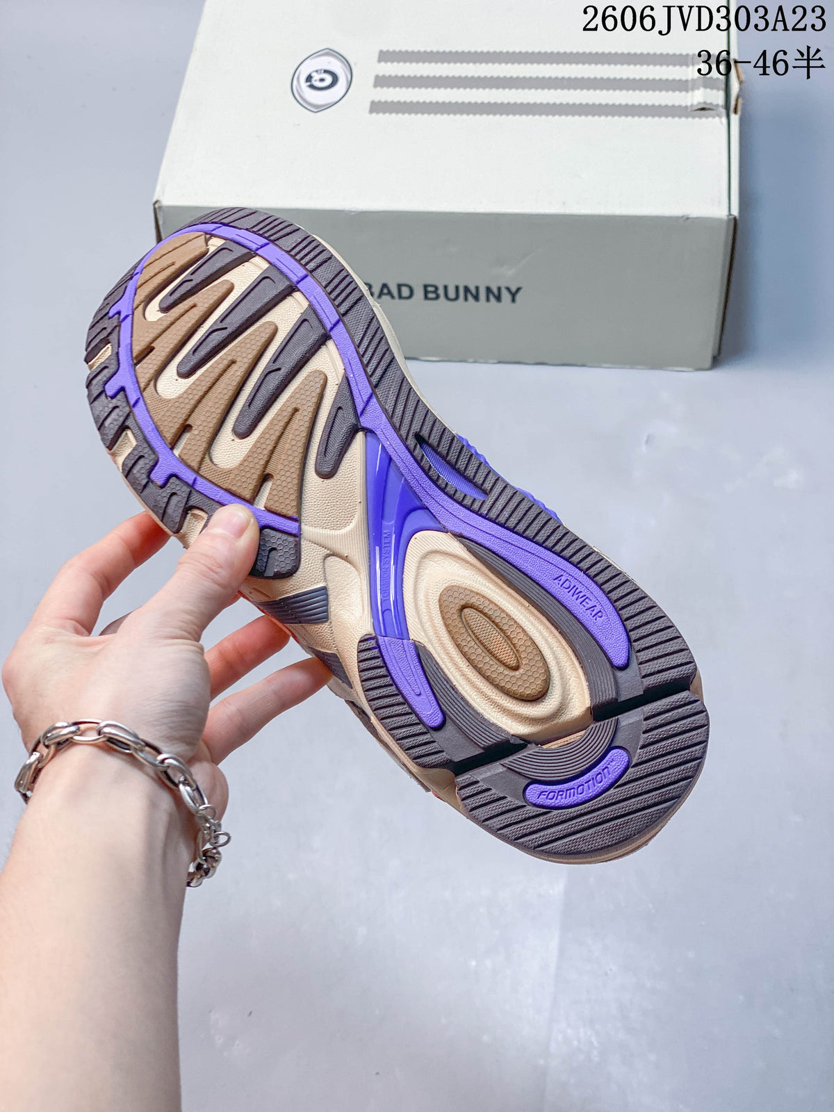 Close-up of the sneaker outsole with beige, dark gray and purple sections