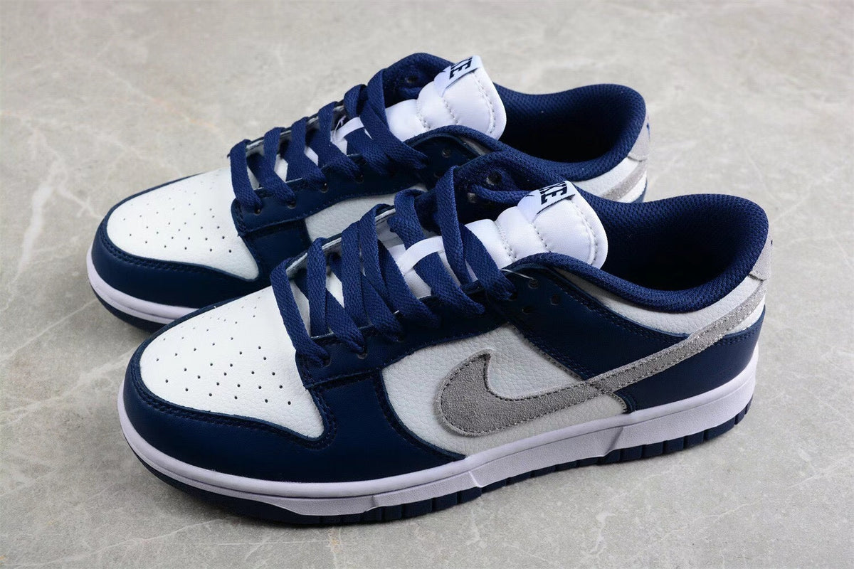 Pair of low-top sneakers shown from an angled front-side view in navy, white, and gray.