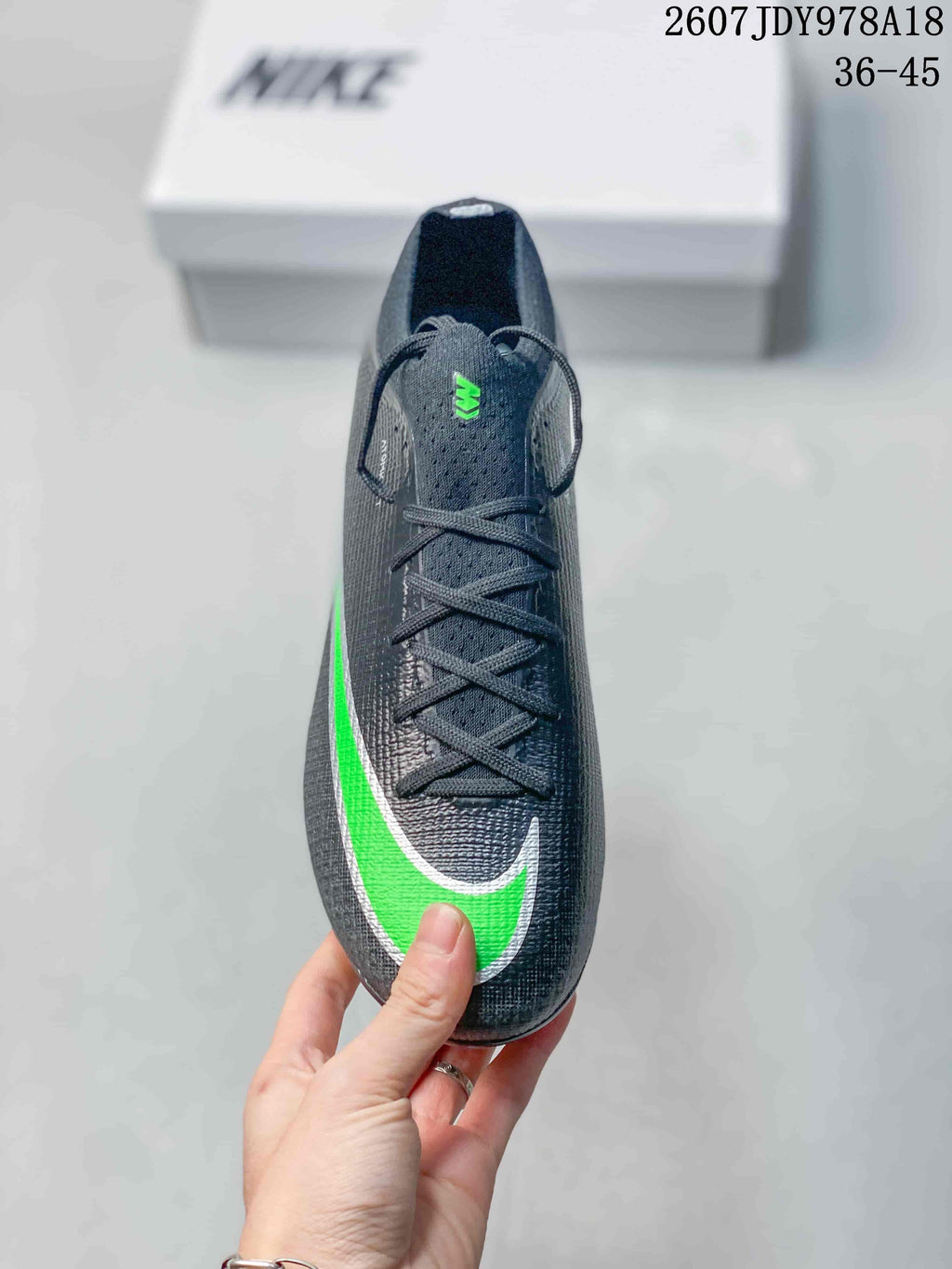 Top view showing the black lace-up upper, green-and-white Swoosh, and green tongue detail.