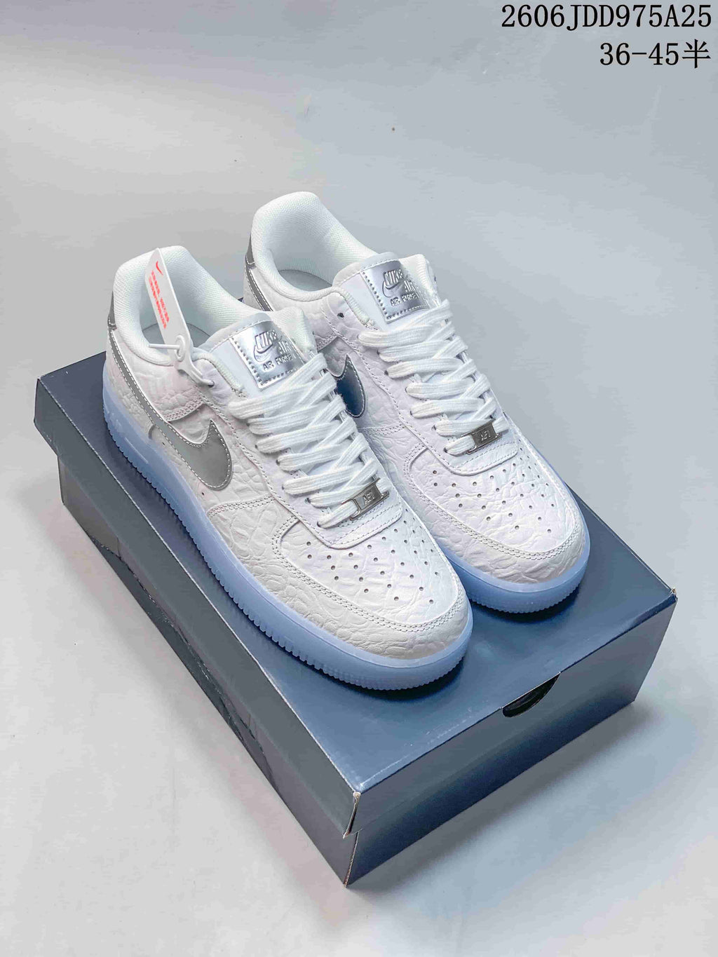 White low-top Air Force 1 sneakers with silver Swoosh details and icy blue soles