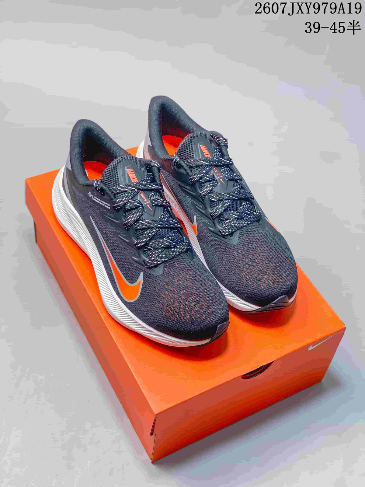 Pair of dark gray and orange Nike Zoom Winflo 7 running shoes displayed on an orange shoebox; image text shows style code 2607JXY979A19 and size range 39–45.