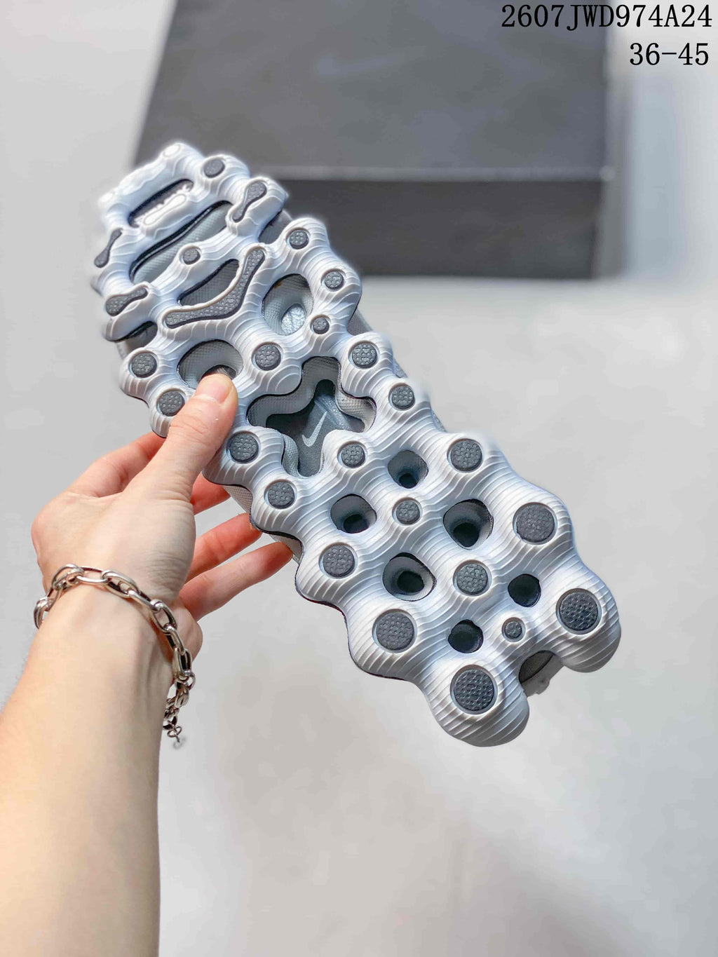 Bottom view of a Nike Air Liquid Max sneaker showing the segmented white outsole with dark traction pods.
