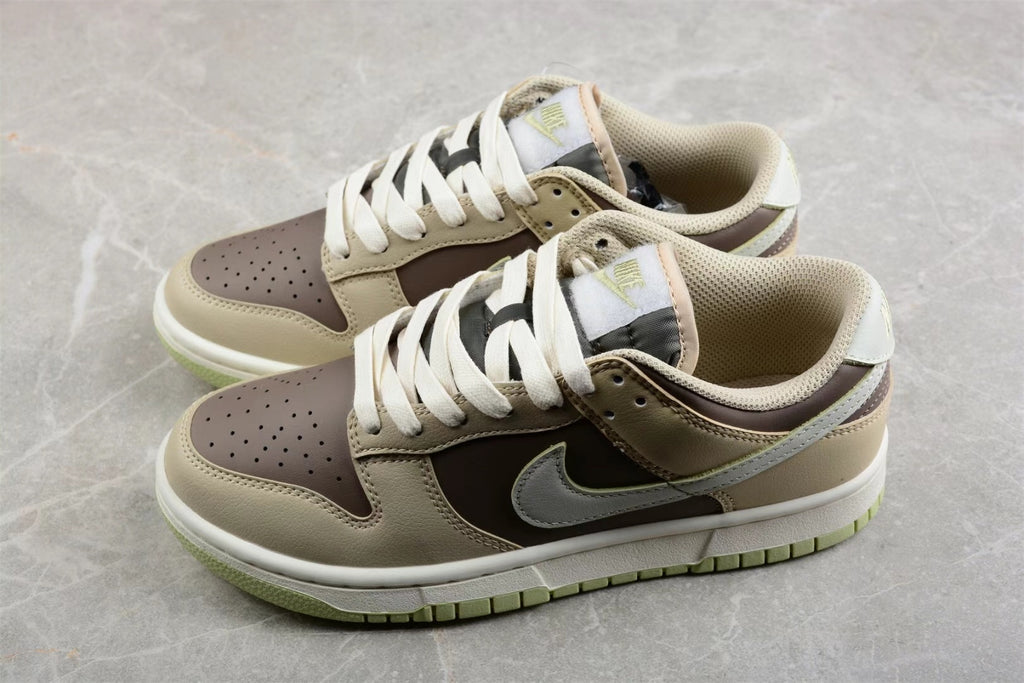 Three-quarter view of the low-top beige and brown sneakers with white midsoles and light green outsoles.