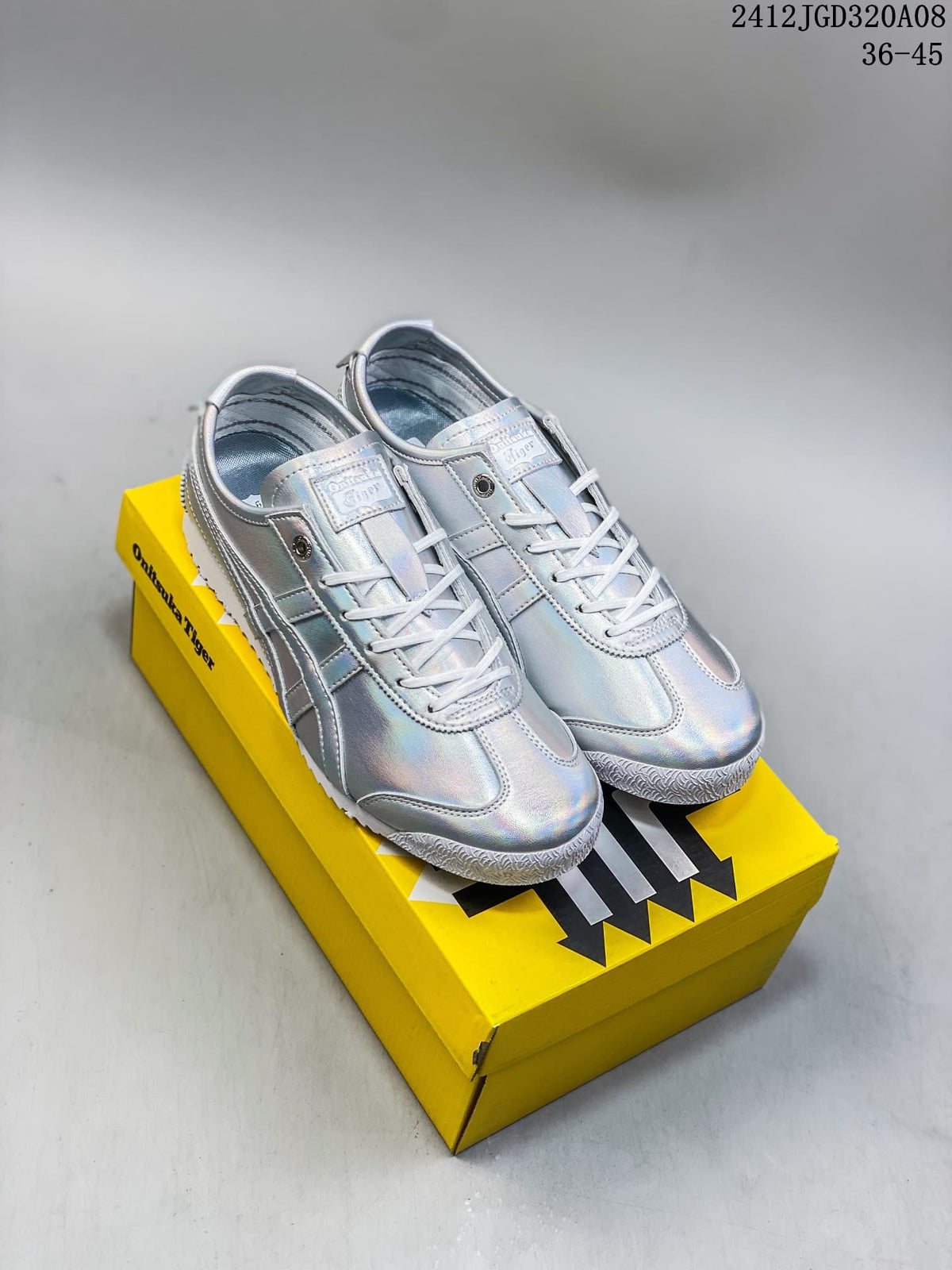 Pair of silver low-top sneakers with a reflective-looking finish displayed on a yellow shoebox.