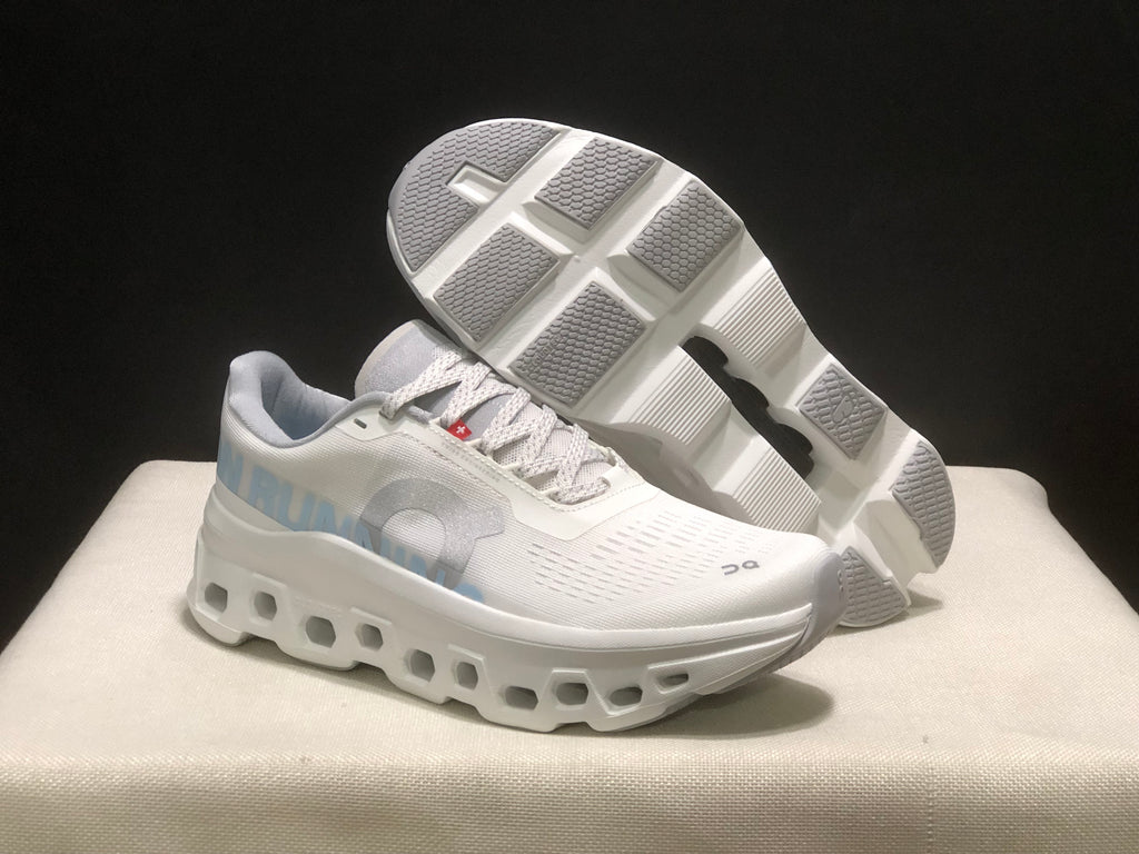 Angled view of the shoes with one outsole lifted, showing the segmented tread and geometric outsole openings.