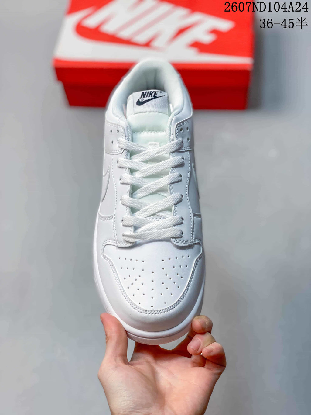 Top view of a white lace-up sneaker showing the perforated toe box and tongue label.
