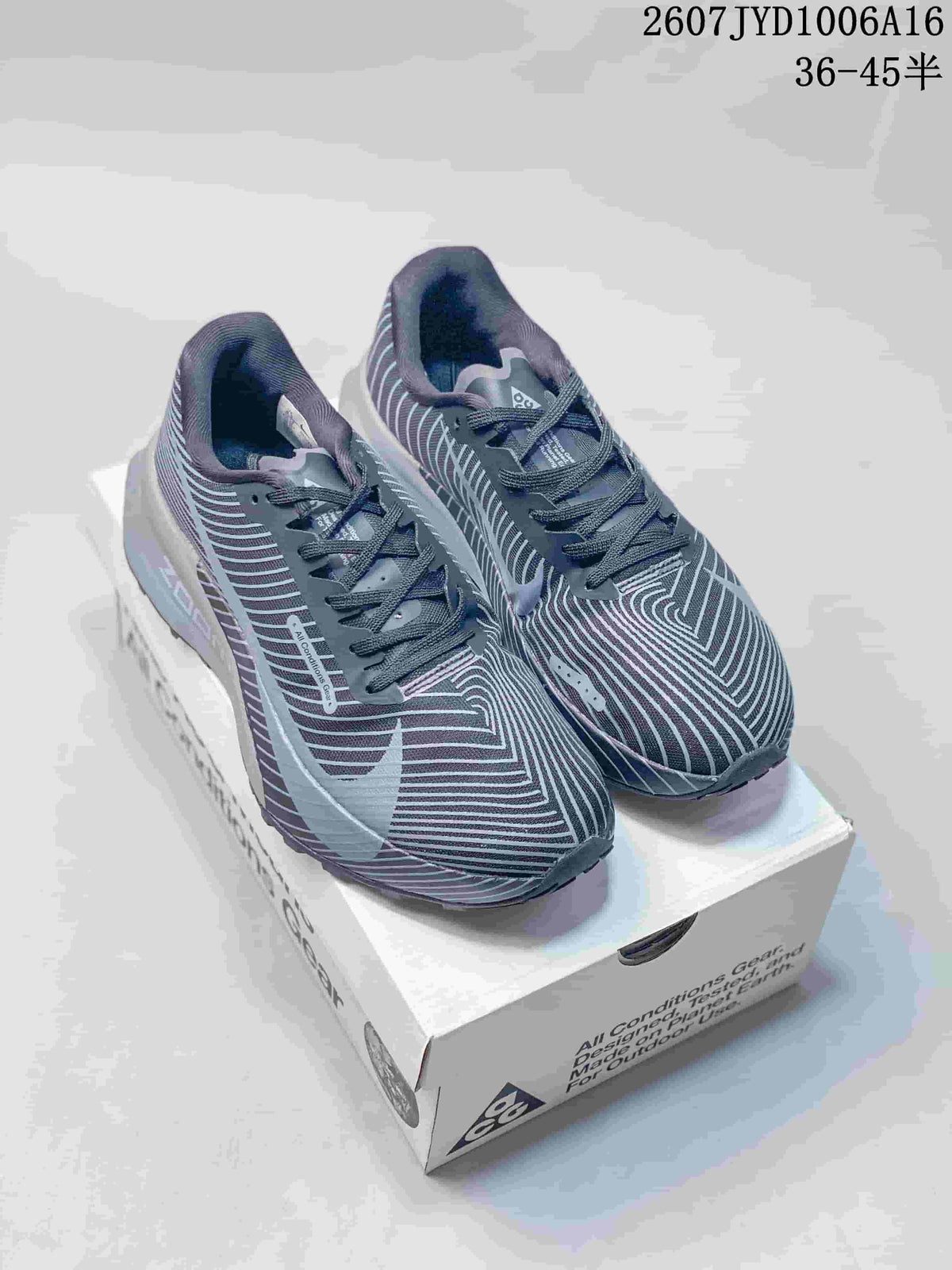 Pair of gray and black Nike ACG trail sneakers displayed on a shoe box.