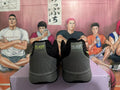 Rear view of black and gray Nike sneakers showing padded collars, stitched heel panels, and gray soles.