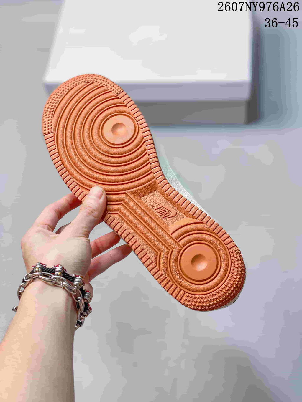 Close view of the orange textured rubber outsole with concentric traction patterns and Nike branding; image text shows 36–45.