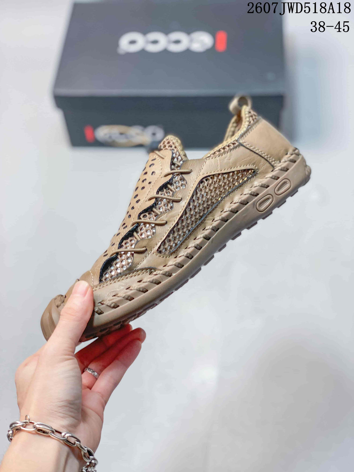 Side view of the tan ECCO sneaker showing perforations, mesh panel, lace-up construction and textured sole.