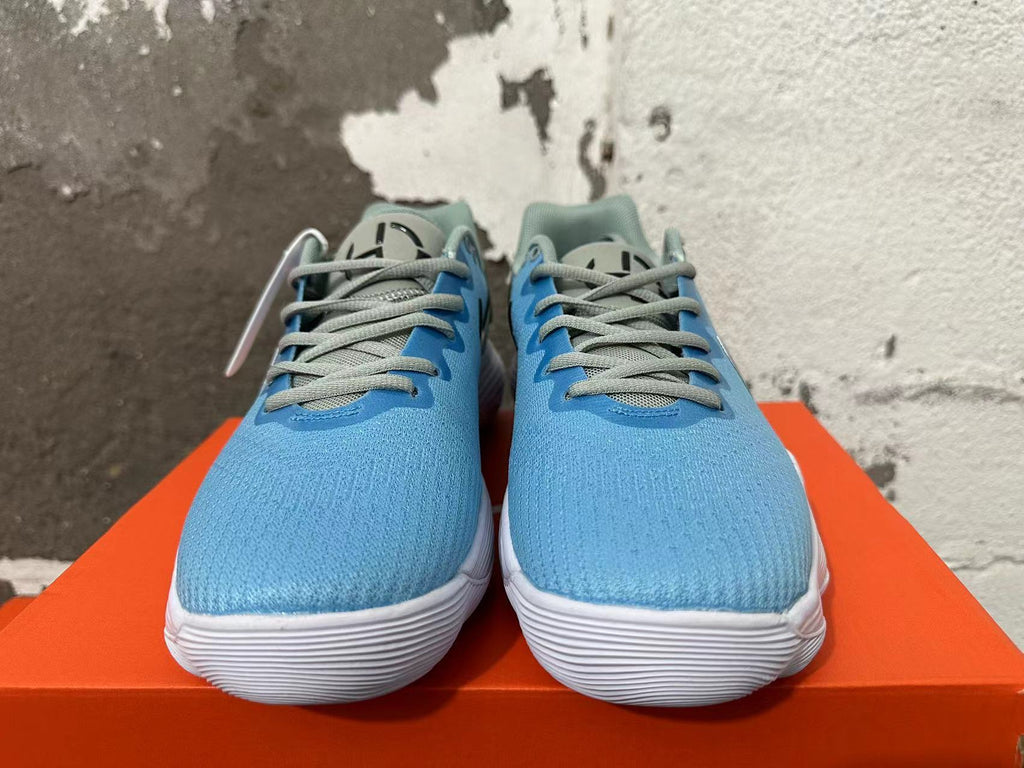 Front view of blue Nike sneakers with gray-green laces and white soles