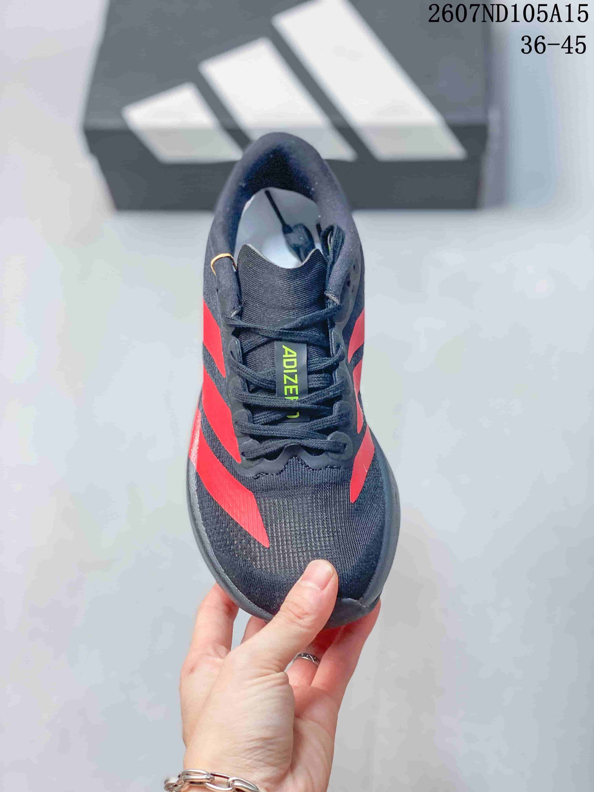 Top view of the sneaker showing the black mesh-like upper, lace system, tongue, and green Adizero branding.
