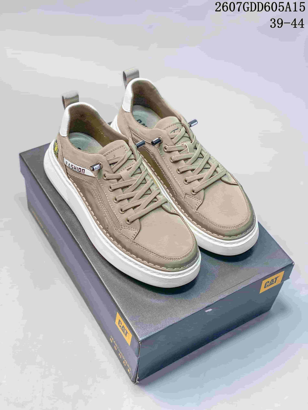 Taupe CAT casual sneakers with lace-up fronts, stitched panels, white outsoles and a branded shoe box.