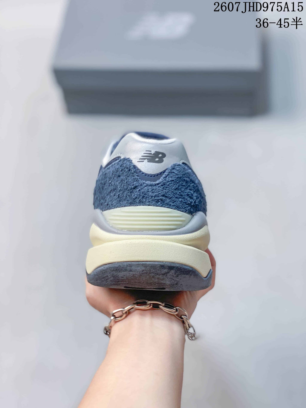 Rear view showing the textured navy heel panels, white branding area, and layered midsole.