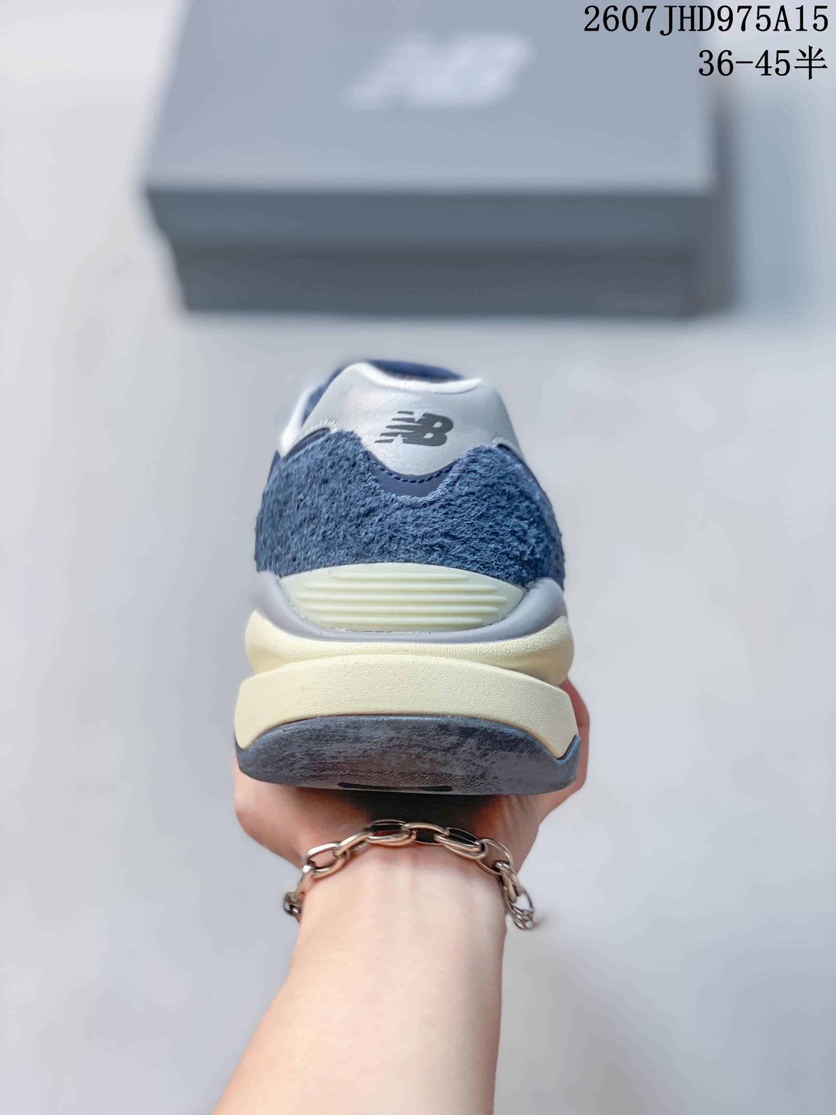 Rear view showing the textured navy heel panels, white branding area, and layered midsole.