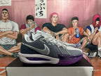 Side view of a Nike basketball shoe in dark gray, light gray, and purple with a dotted Swoosh and white midsole.