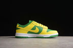 Side profile showing the yellow overlays, green panels, Nike Swoosh, and white midsole.