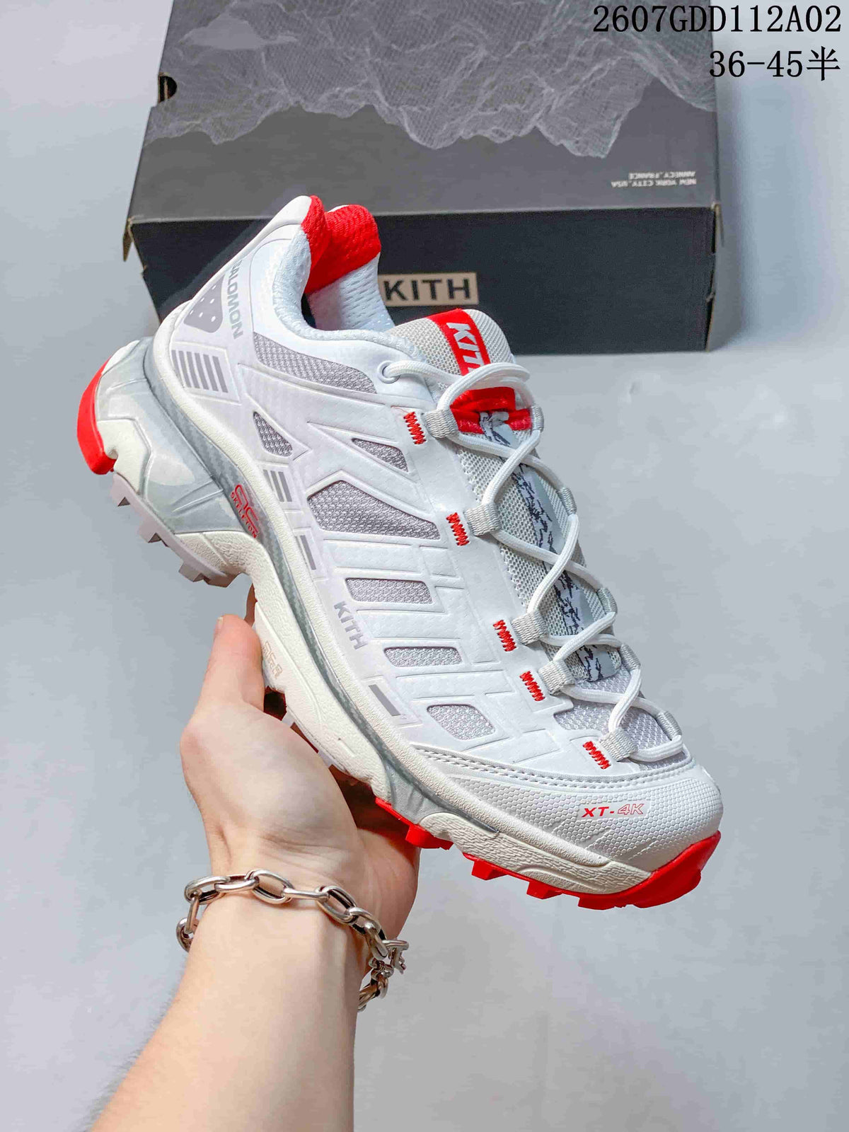 Side view of a white and red Salomon XT-4K sneaker with a quick-lace system.