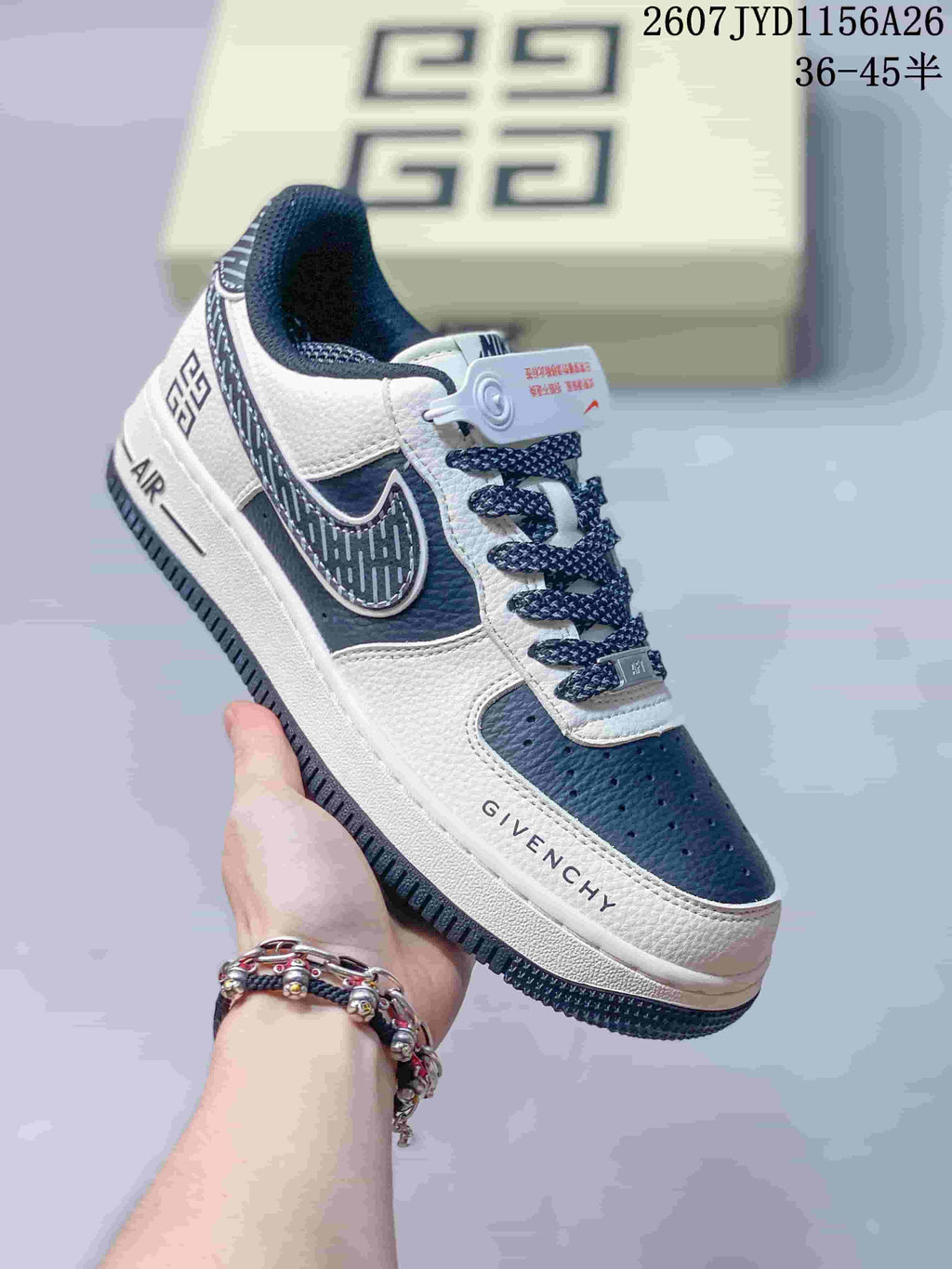 Angled side view of the white and navy sneaker showing the side graphics, AIR-marked midsole, and printed Givenchy detail.