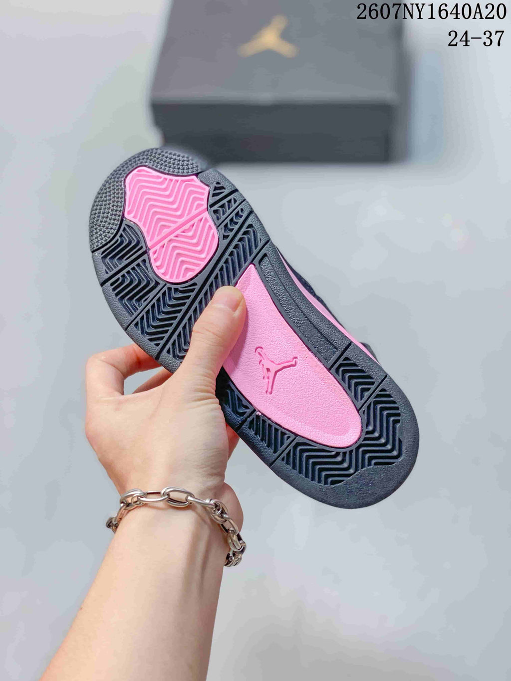 Outsole view showing the black patterned tread and pink center section.