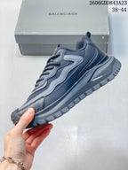 Side profile of the grey sneaker with layered overlays and a rugged sole.
