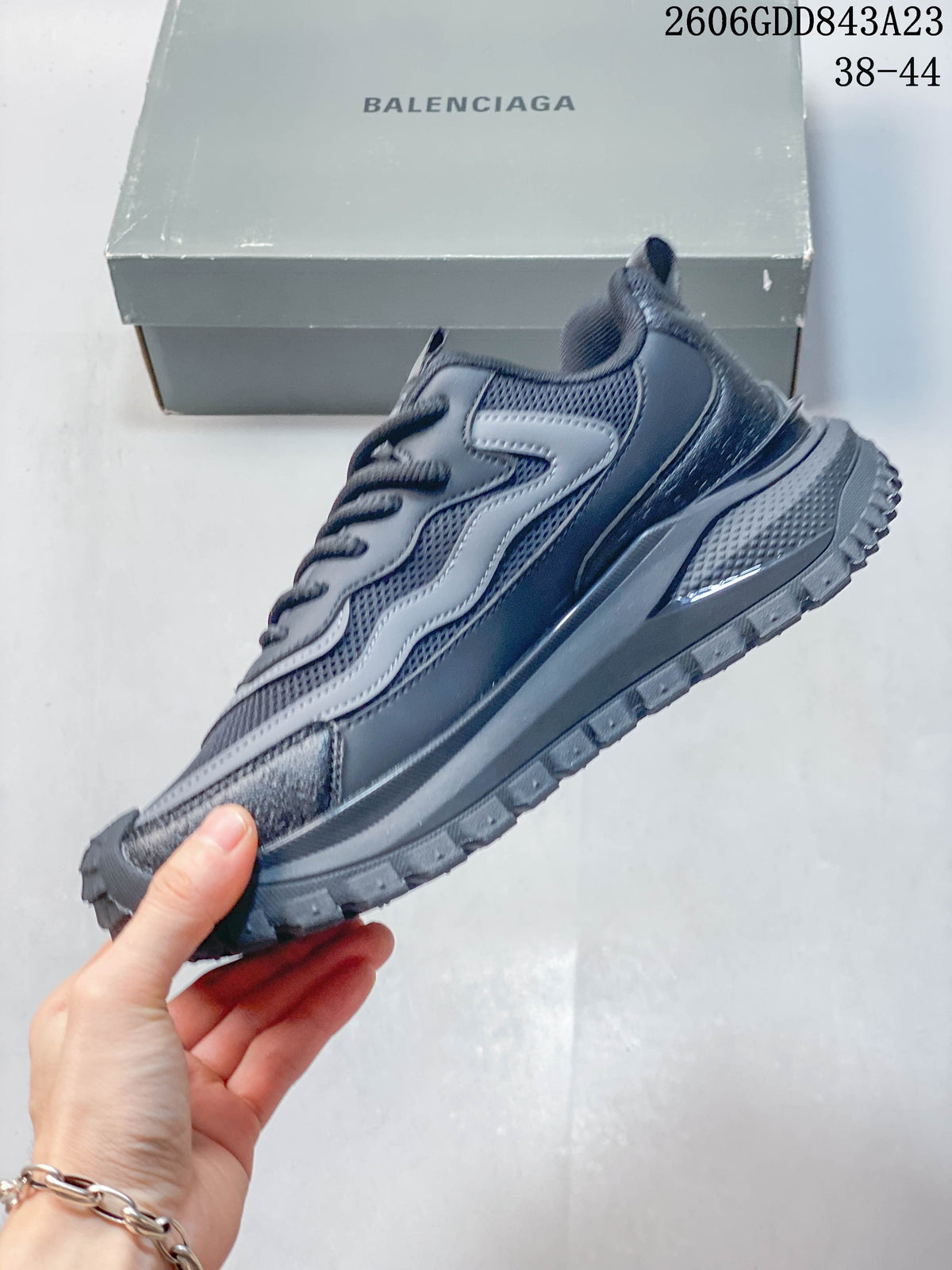 Side profile of the grey sneaker with layered overlays and a rugged sole.