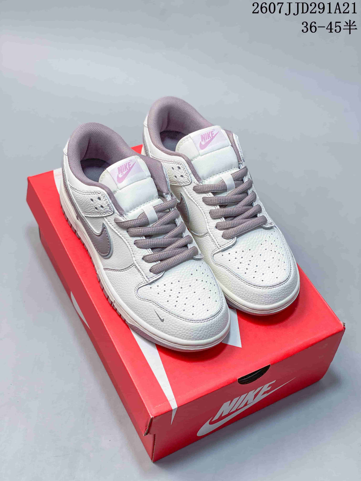 Pair of white and gray Nike sneakers displayed on a red shoebox, showing perforated toe boxes, gray laces, and padded collars.